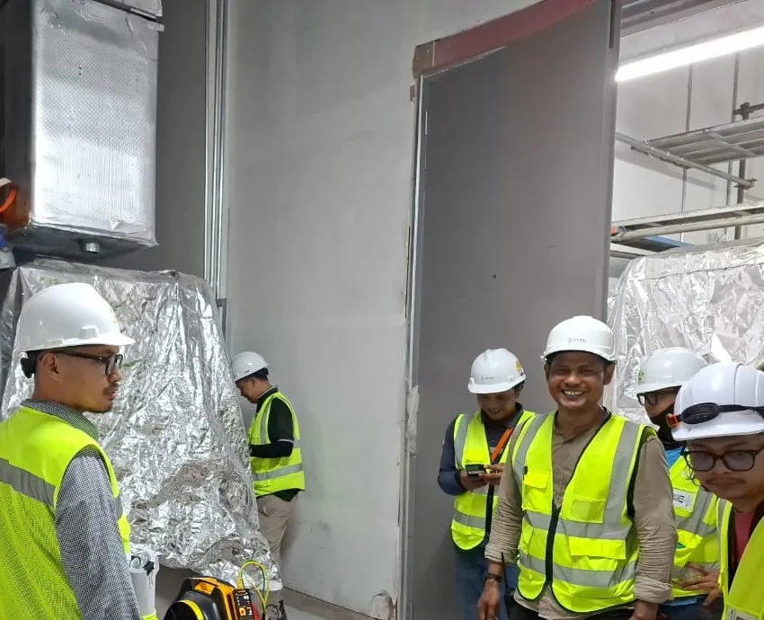 The duct test rig connected at the battery room air handling units, with the site team gathered around it.